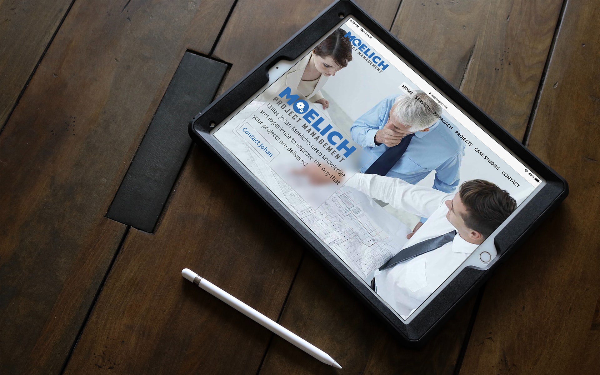 iPad displaying the Moelich Project Management home page, on a table.