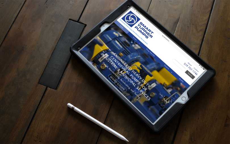 iPad on wooden table displaying Smart Turner Pumps landing page.