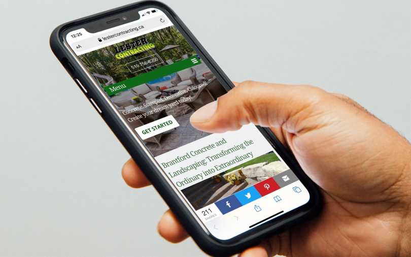 Woman holding iPhone displaying Lester Contracting home page.